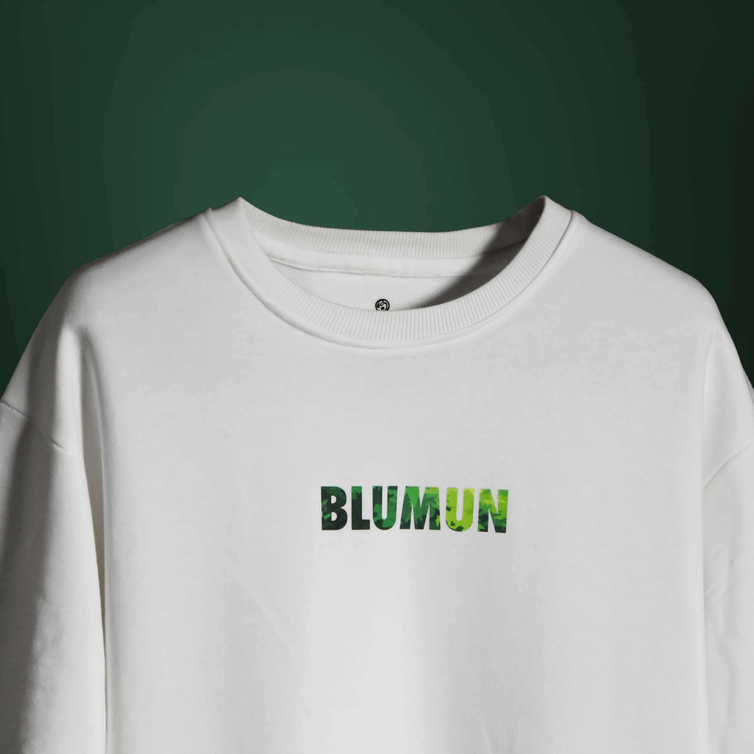 Front view of the Bonsai Tree T-Shirt featuring the word “BLUMUN” in a green, foliage-textured font on a plain white background.