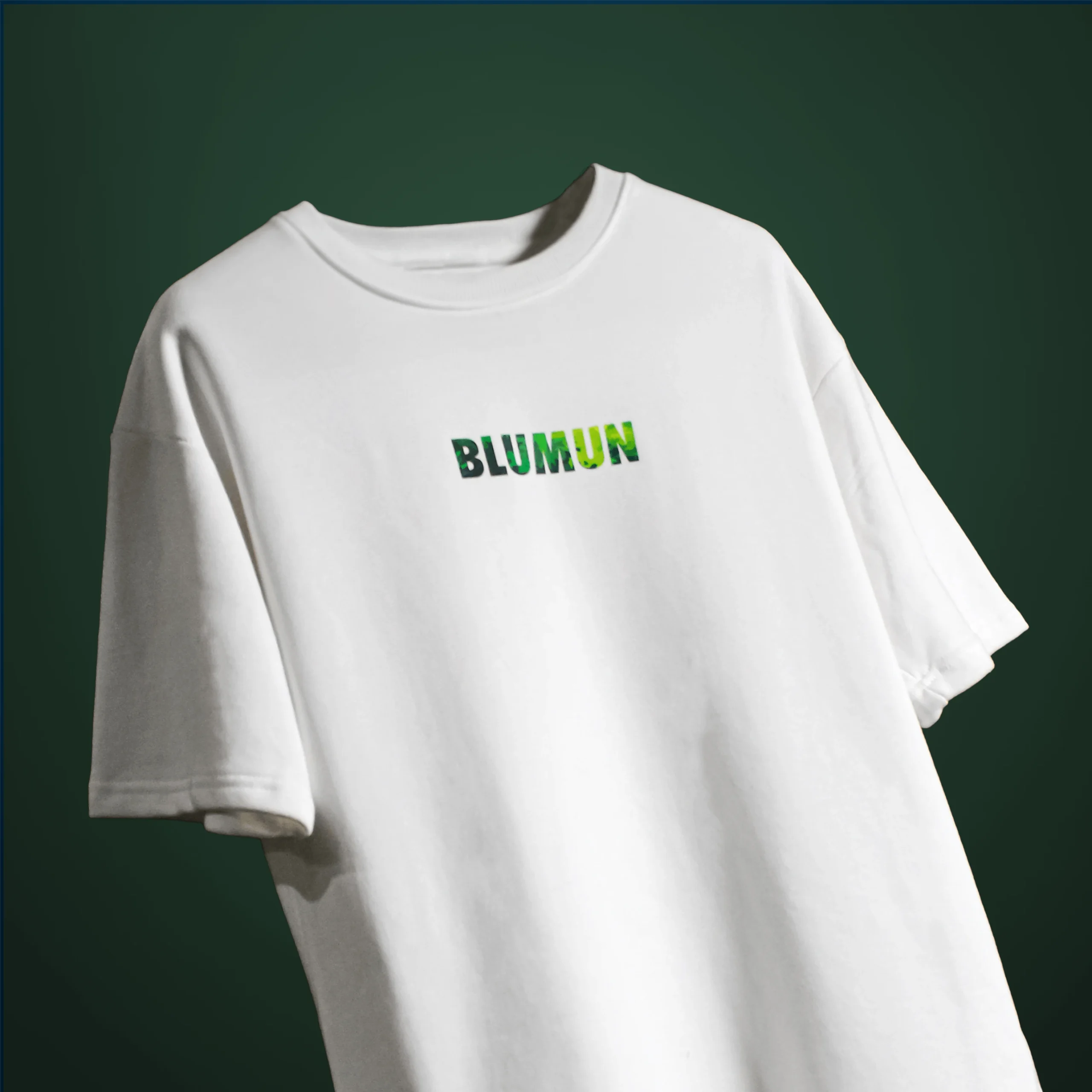 Front view of the Bonsai Tree T-Shirt featuring the word “BLUMUN” in a green, foliage-textured font on a plain white background.